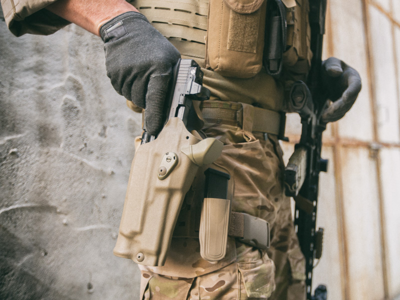 Military service member drawing firearm from Safariland RDS tactical holster