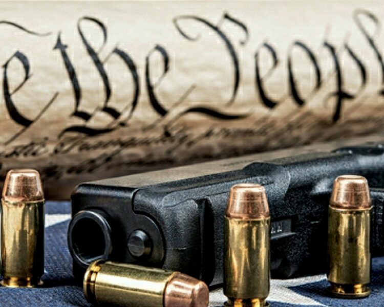 A handgun and ammunition beside the US Constitution