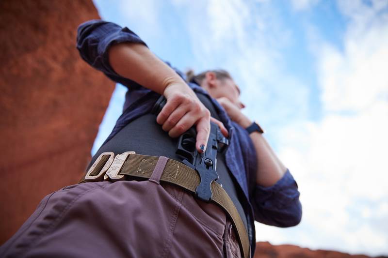 Person drawing a pistol from a Schema holster worn AIWB