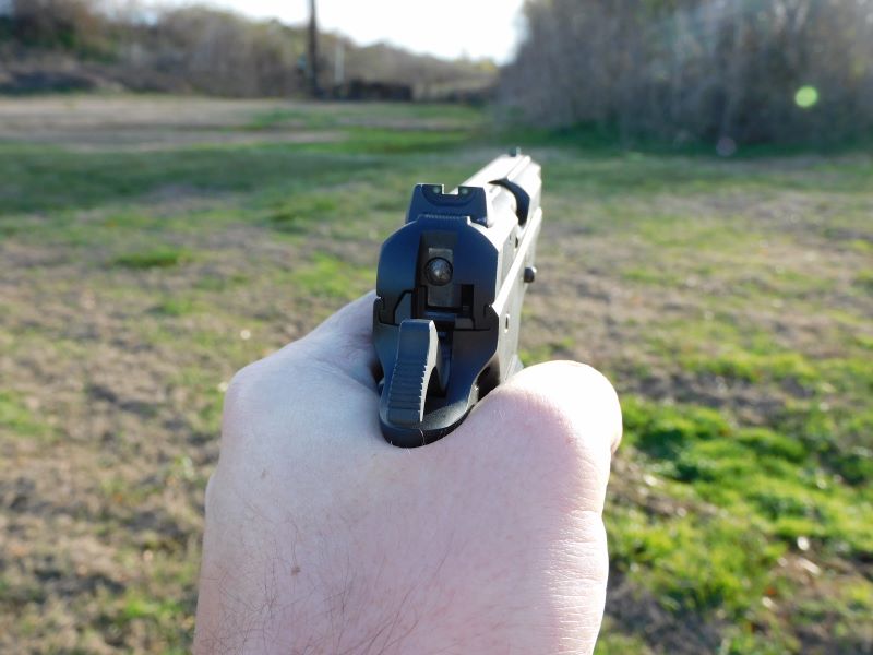 posterior view of handgun, aiming downrange
