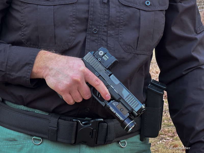 Man holsding Glock handgun with Aimpoint ACRO P-2 red dot and TLR-1