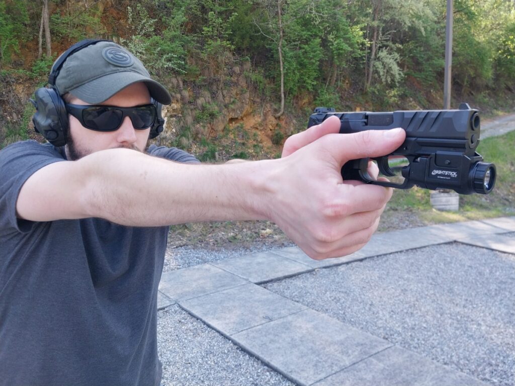 Man firing a Walther PD380 with a weapon light
