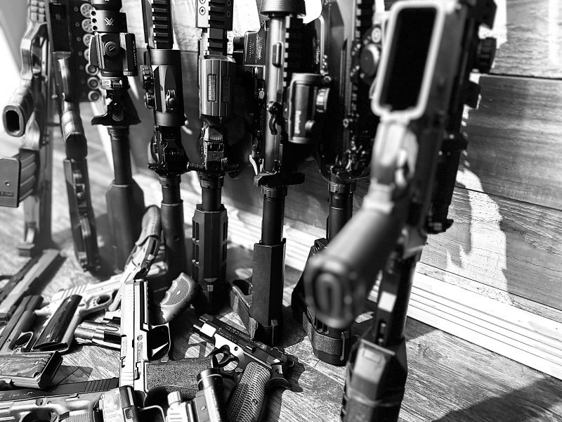 black and white photo of rifles and handguns 
