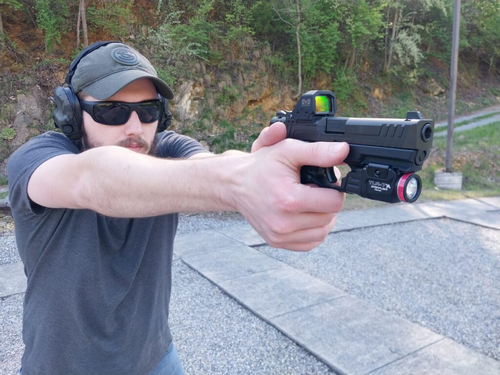 Man firing pistol with Meprolight MPO-F red dot