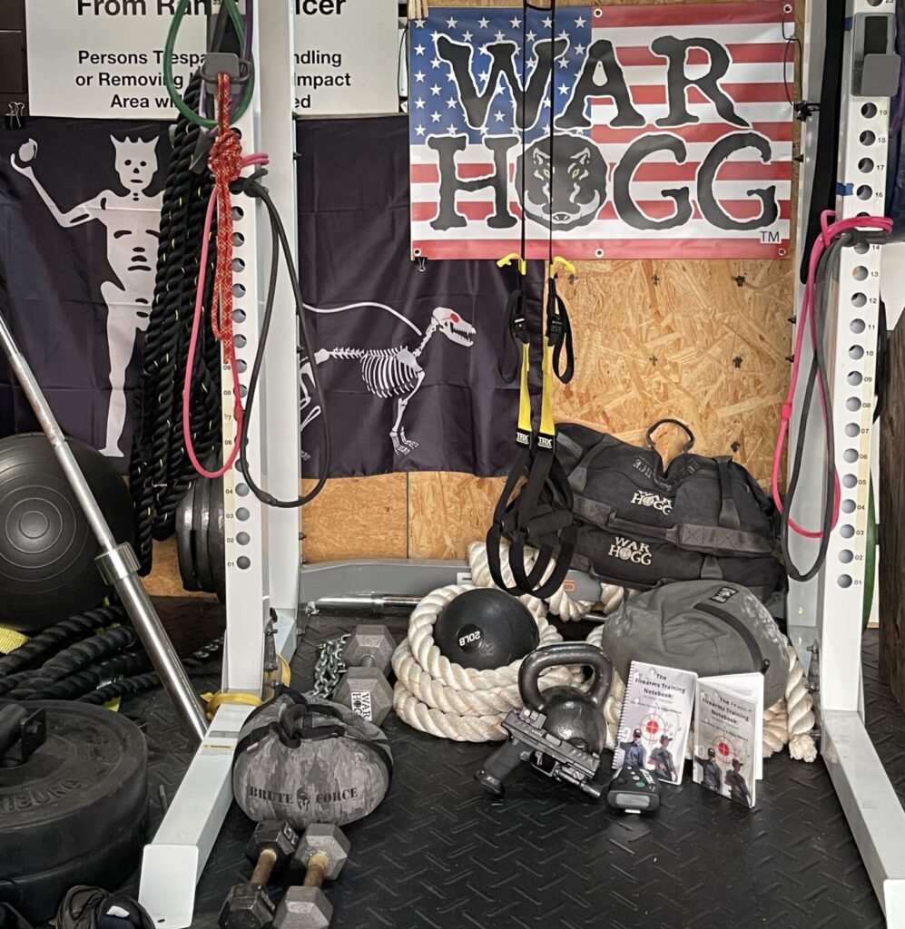 pictured is the War HOGG combat training center with a rack, sandbags, ropes and more