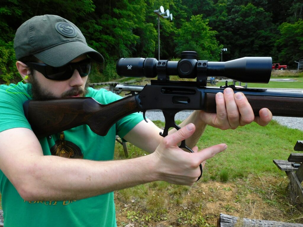 Man firing a lever action rifle