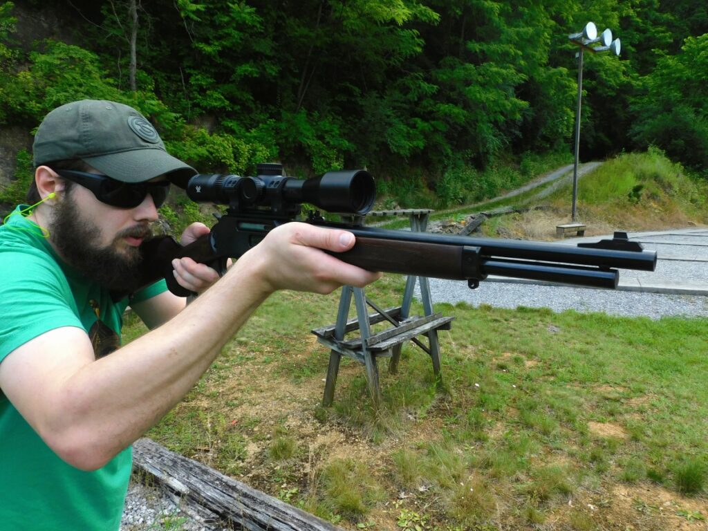 Man firing a lever action rifle