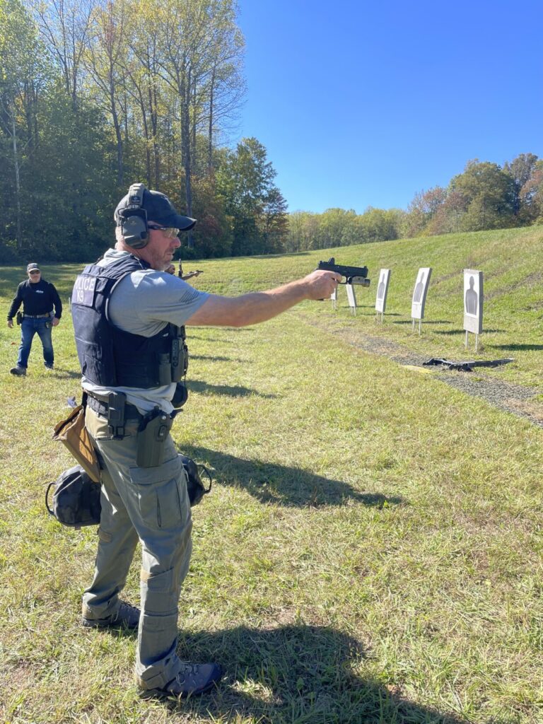 A Law Enforcement K9 Handler shooting one handed using a sandbag to add realism to his training