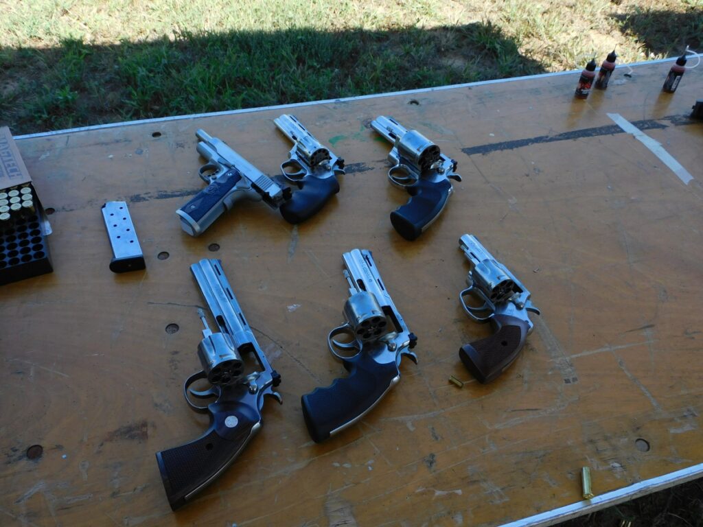 Table at TriggrCon 2024 with Colt revolvers and Gold Cup Trophy 1911