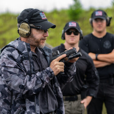 Rick Hogg is explaining to law enforcement officers about using the front sight post as a reference when presenting a red dot equipped pistol