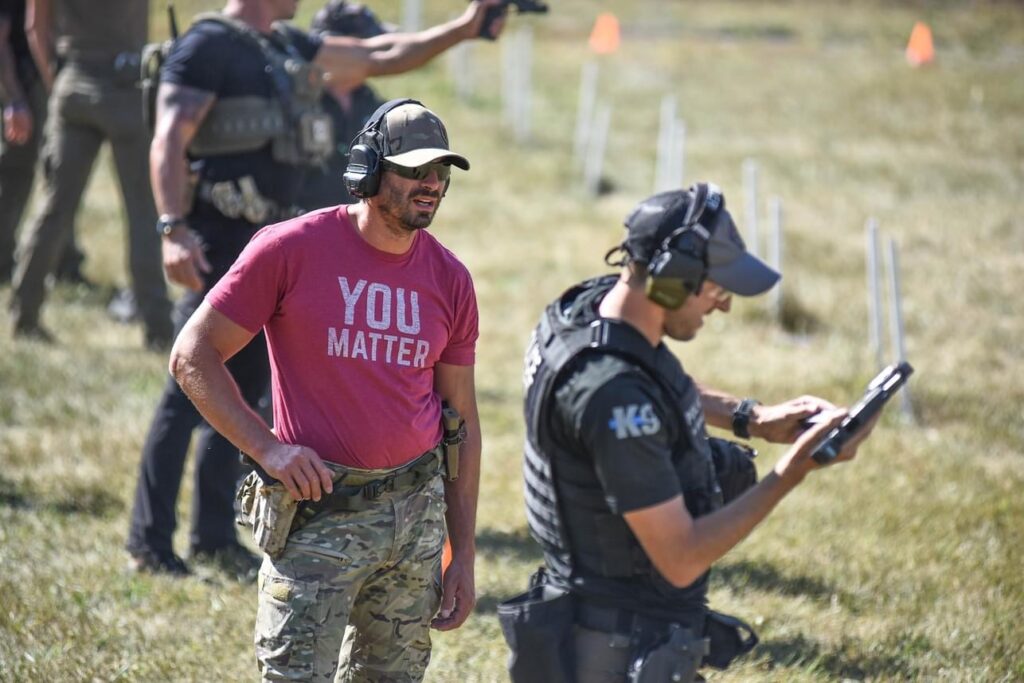 Law enforcement student observing another officer conduct the pistol speed magazine change photo by Laura Fogarty