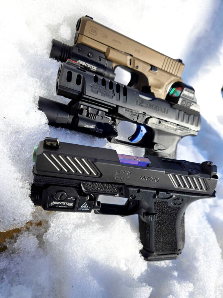 collection of handguns in snow