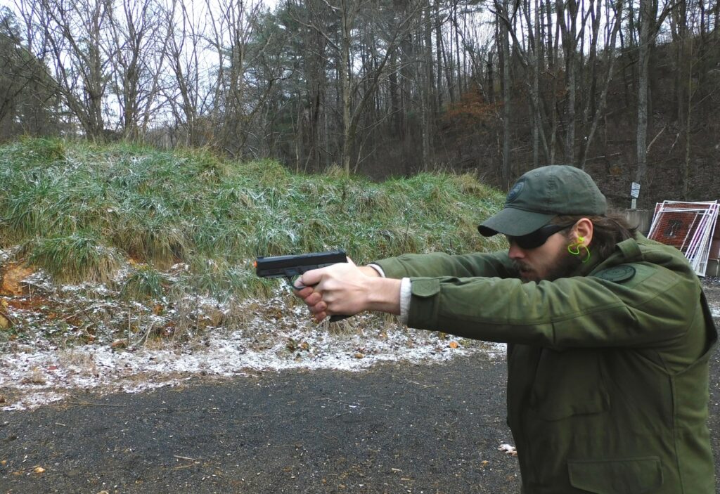 man firing a semi-automatic pistol