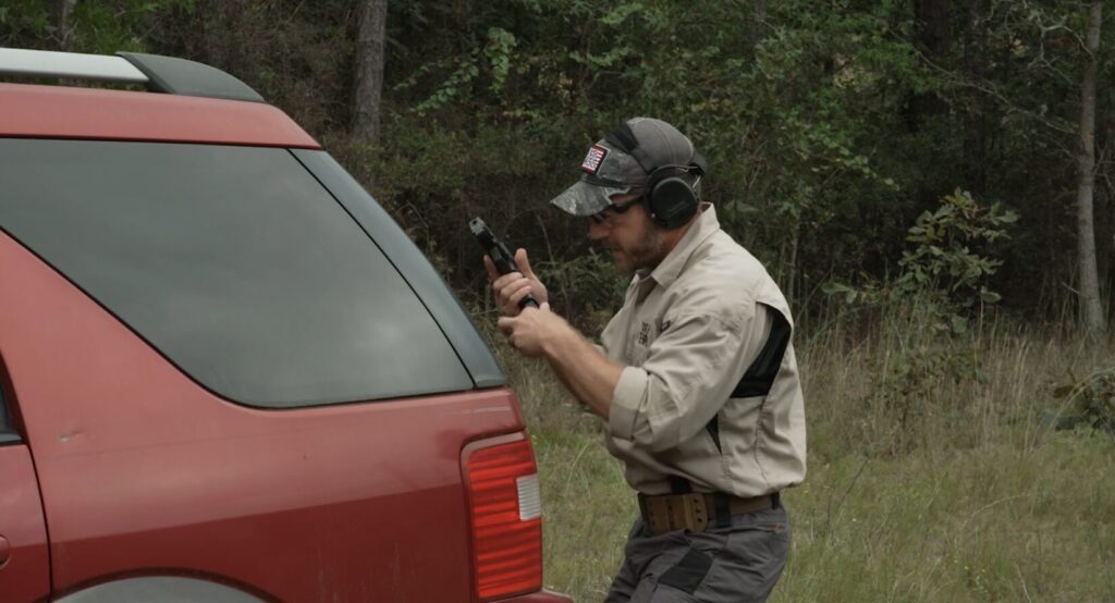 Rick Hogg of War HOGG Tactical conducting a tactical magazine change behind a vehicle after an engagement