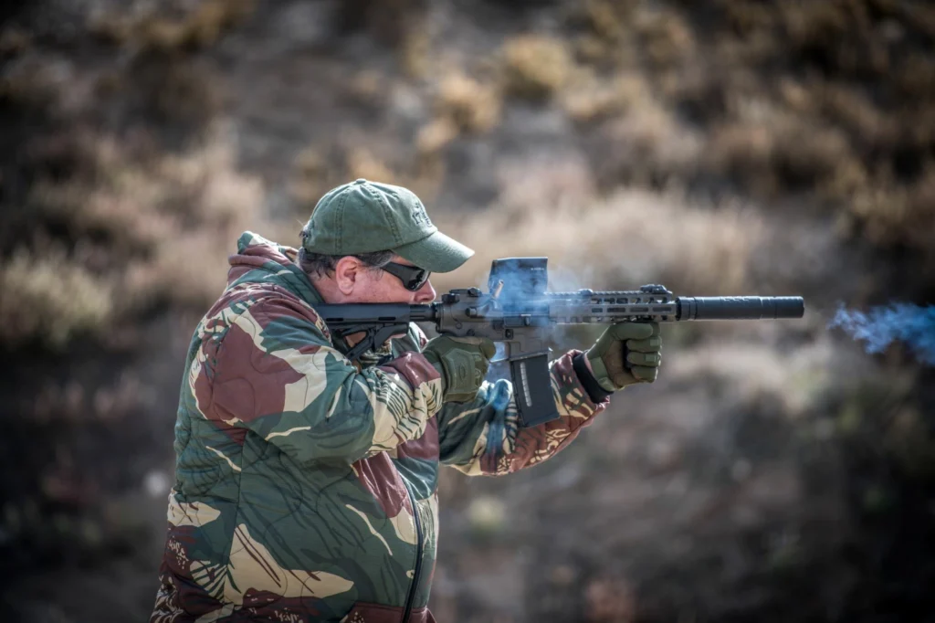 Man firing a suppressed AR-15 rifle