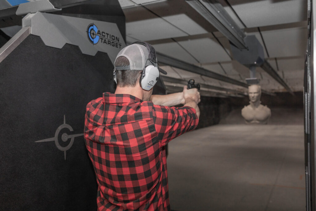 Man shooting at a Birchwood Casey 3d Silhouette target in indoor range.