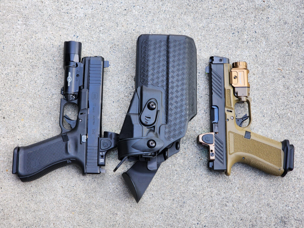 A Glock 17 and a Shadow Systems MR918, both fitted with the Radian Afterburner + Ramjet, shown side by side with a Safariland duty holster in between