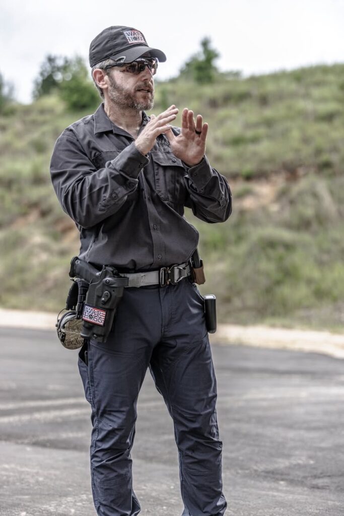 In this photo, Rick Hogg has hands above the waist in preparing to draw from the holster