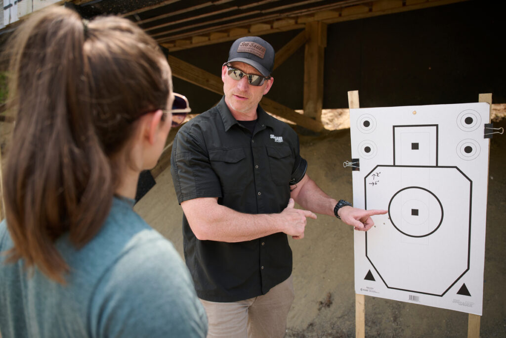Sig Sauer Academy instructor pointing to target while he speaks to a student.
