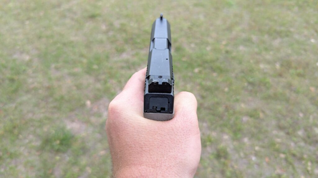 rear view of hand gripping CZ P10 C pistol