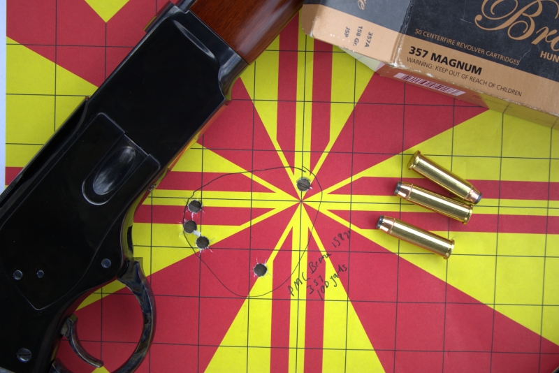 Winchester 1873 on a target showing a 20inch shot group. .357 magnum shells are also on the target.