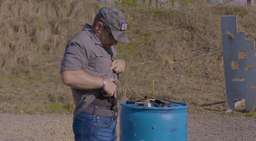 In this photo Rick Hogg from War HOGG Tactical is demonstrating looking at the holster before holstering his concealed firearm.