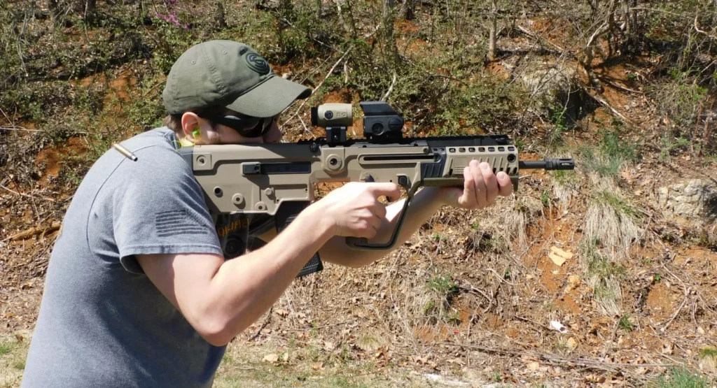 Man firing an IWI Tavor X95 rifle