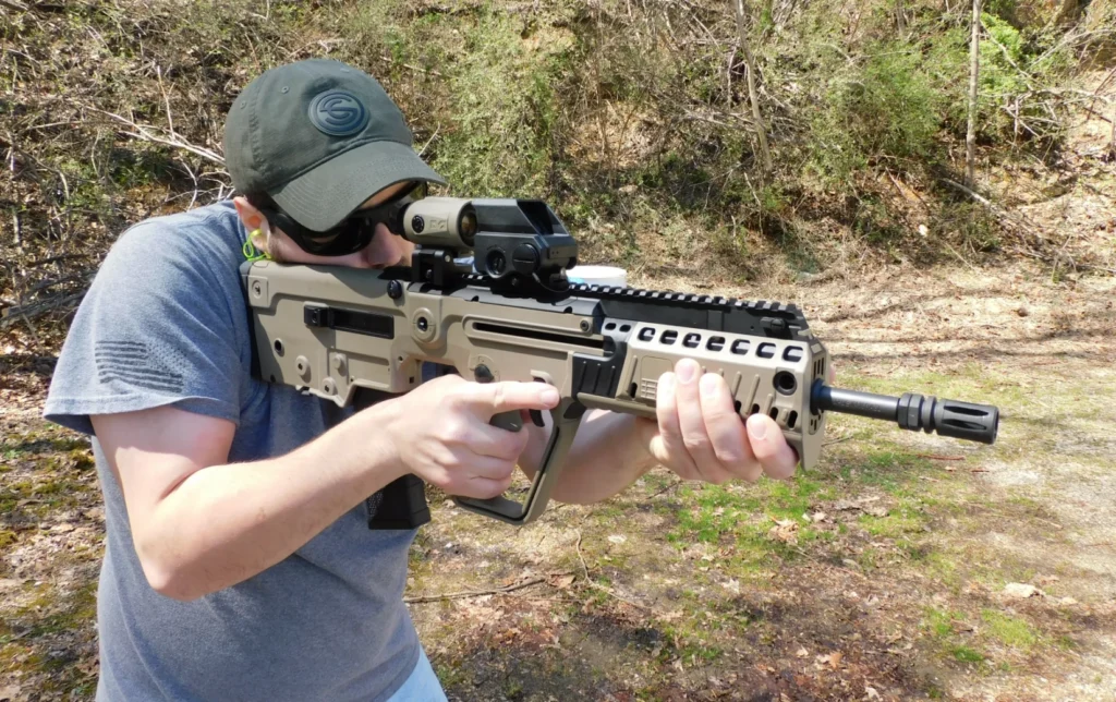 Man firing an IWI Tavor X95 rifle
