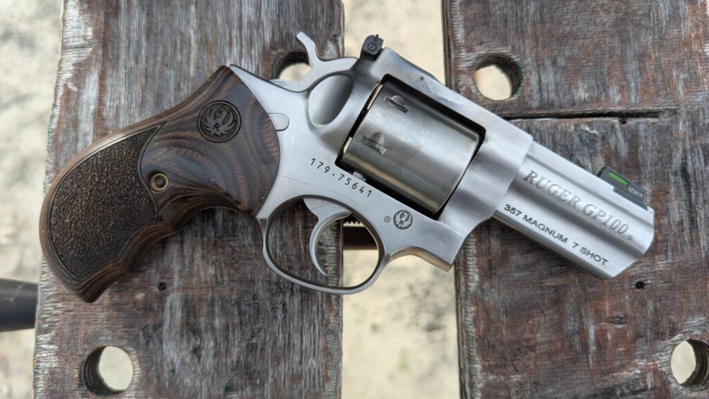 Ruger gp100 on wooden platform.