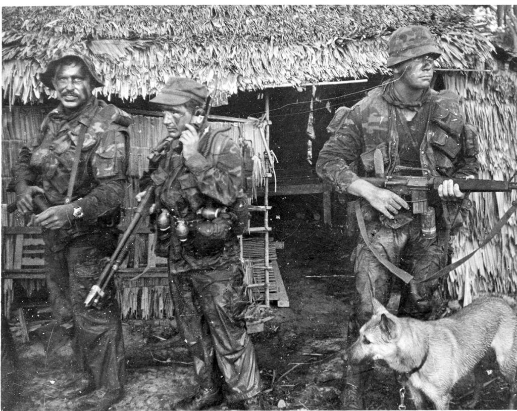 3 camouflaged Navy SEALs with k9 Silver in Vietnam