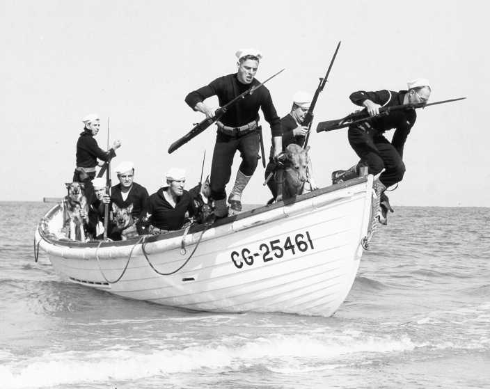 Pictured is a Coast Guard boat with Coast Guardsmen and k9s jumping off a boat