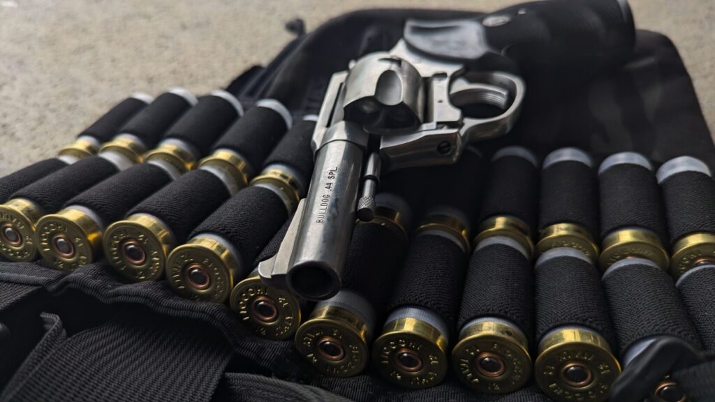 Revolver and shotgun shells on black fabric.