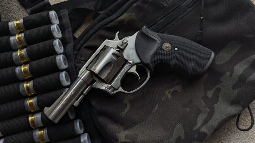 Revolver and shotgun shells on camouflage bag