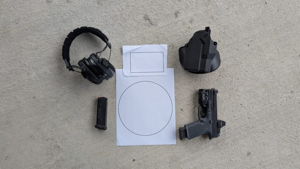 Overhead view of a handgun, ear protection, magazine, shot timer, and a paper target.