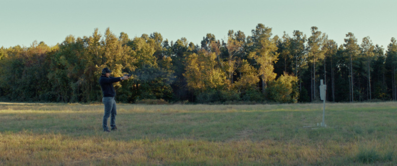 Kyle shooting at a steel target, outdoors.