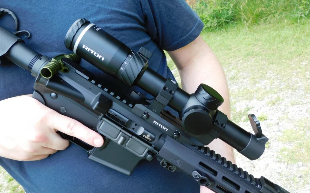 Man holding a scoped AR-15 rifle