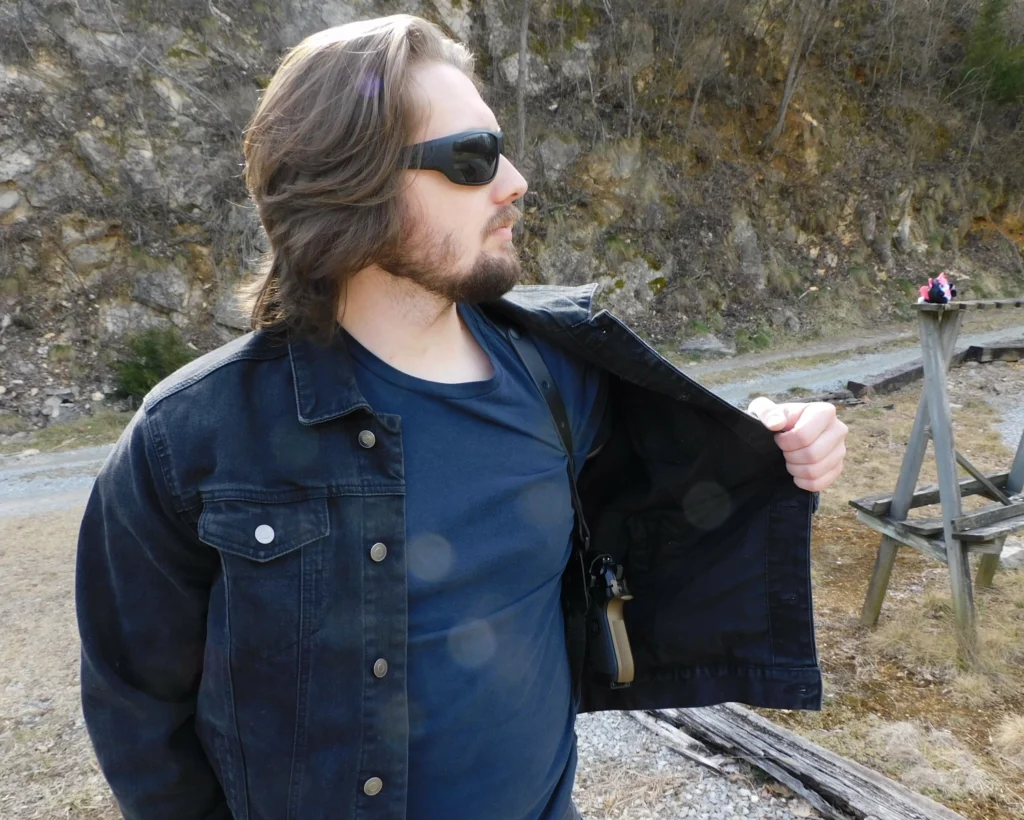 Man wearing a Safariland 1051 ALS Shoulder Holster under a denim jacket