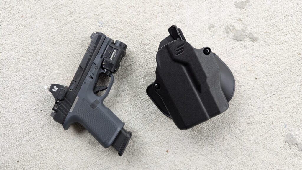 Pistol and Solis holster side-by-side on concrete