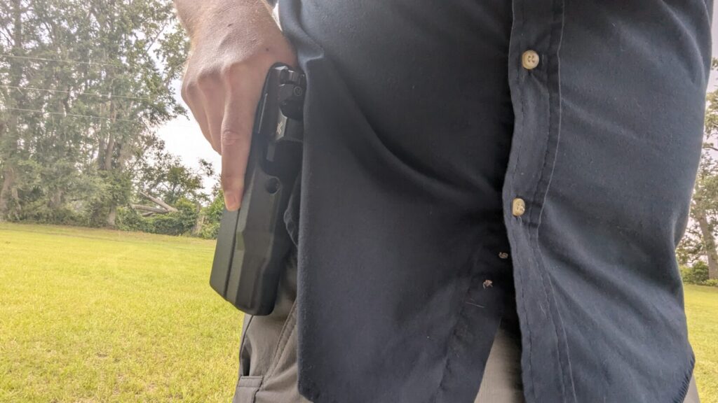 Hand drawing a pistol from a Solis holster.