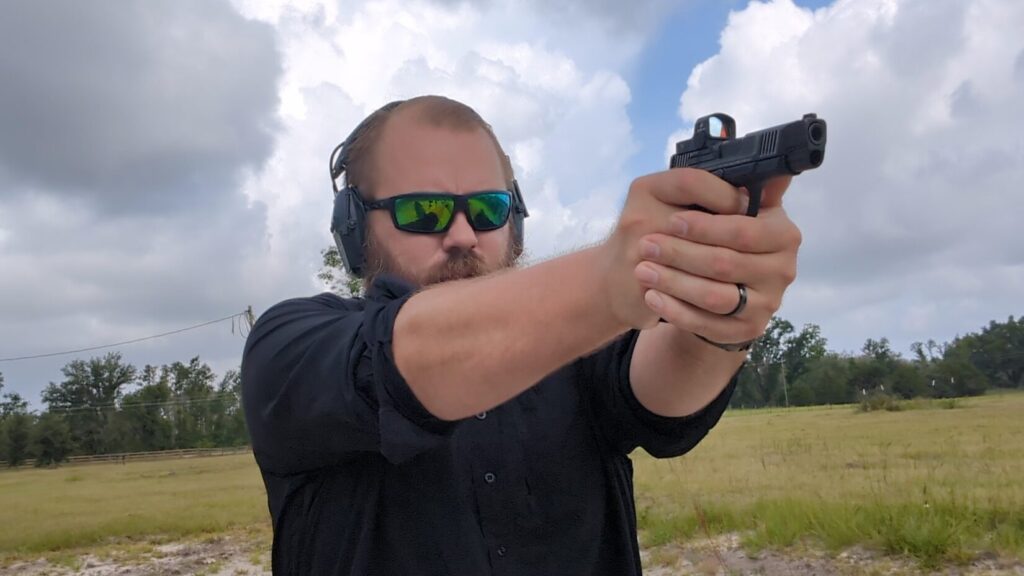 man shooting Smith & Wesson CSX E-Series mounted with Cyelee CAT0 red dot at outdoor range
