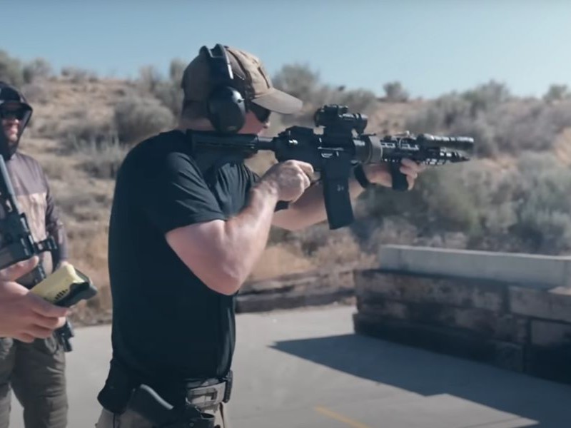 A student on the shooting range fires an AR-15 at a target as students watch. 