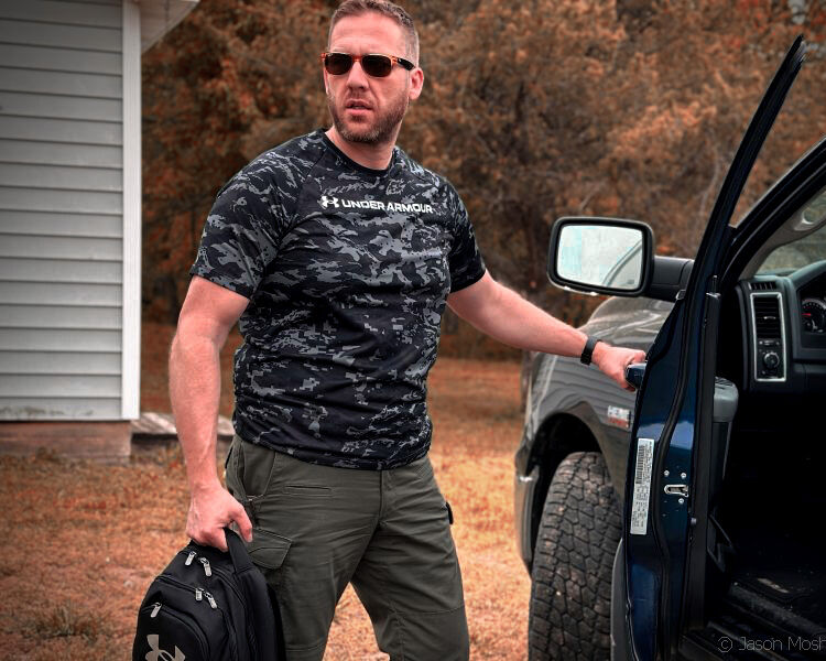 Opening the door to a truck while carrying a backpack in the other hand,