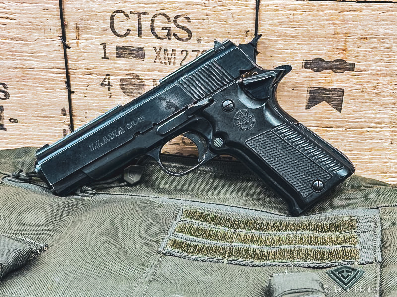 A Llama .45 1911 made in Spain, leaning against wooden ammo crate