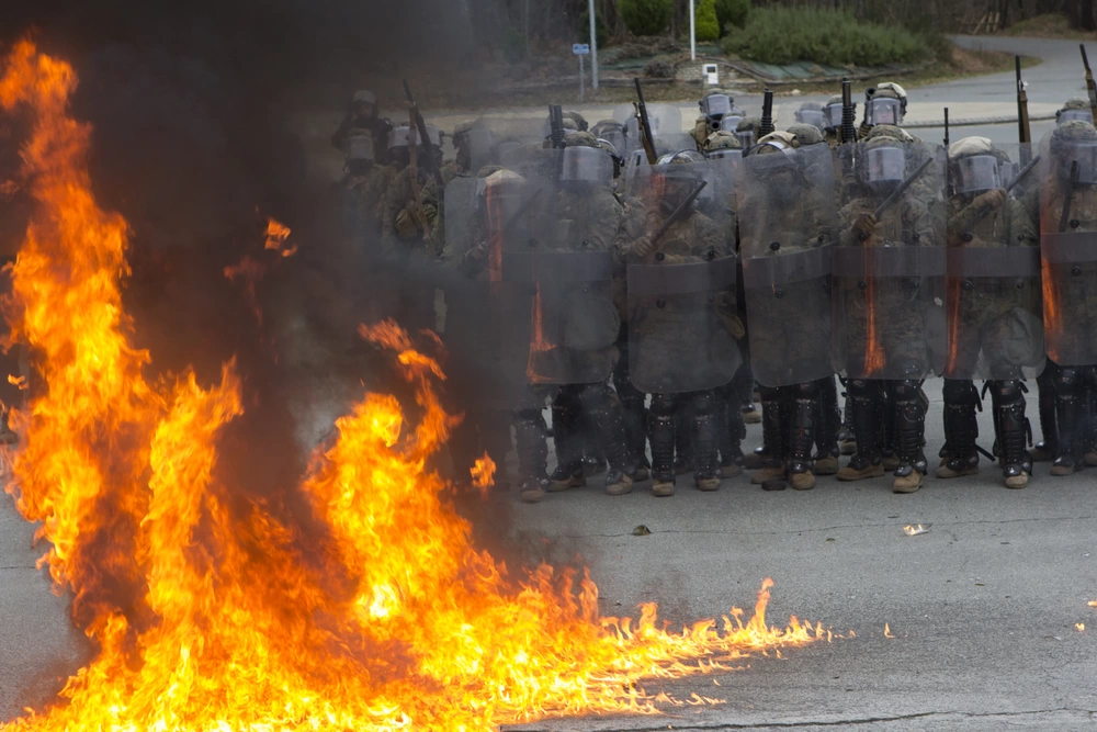 fire burning marines in riot gear