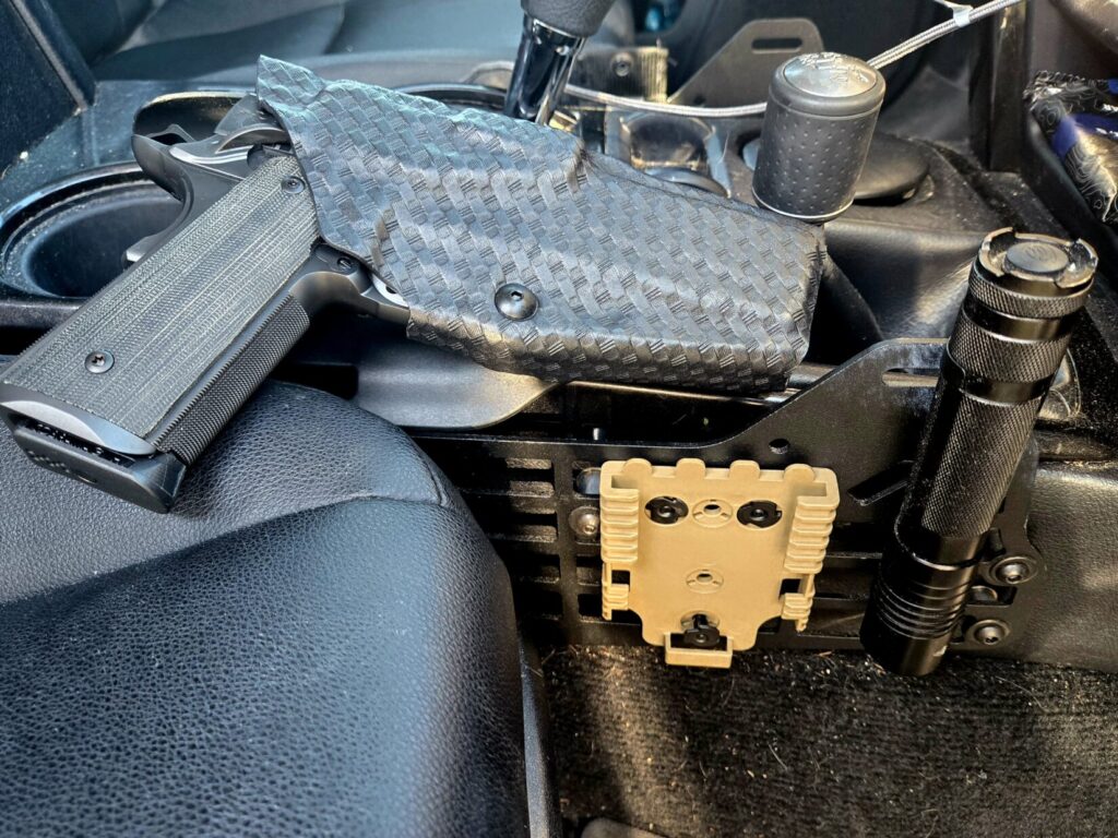 A Kings River Custom 1911 in a Safariland Holster in the center console of a vehicle