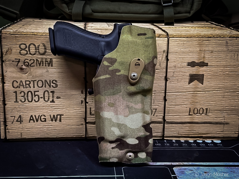 safariland cordura-wrapped holster with Glock, in front of wodden ammo box