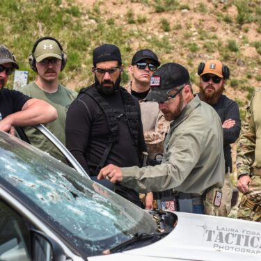 in this photo, Rick Hogg of War HOGG Tactical conducts a windshield inspection with law enforcement officers after a live fire demonstration