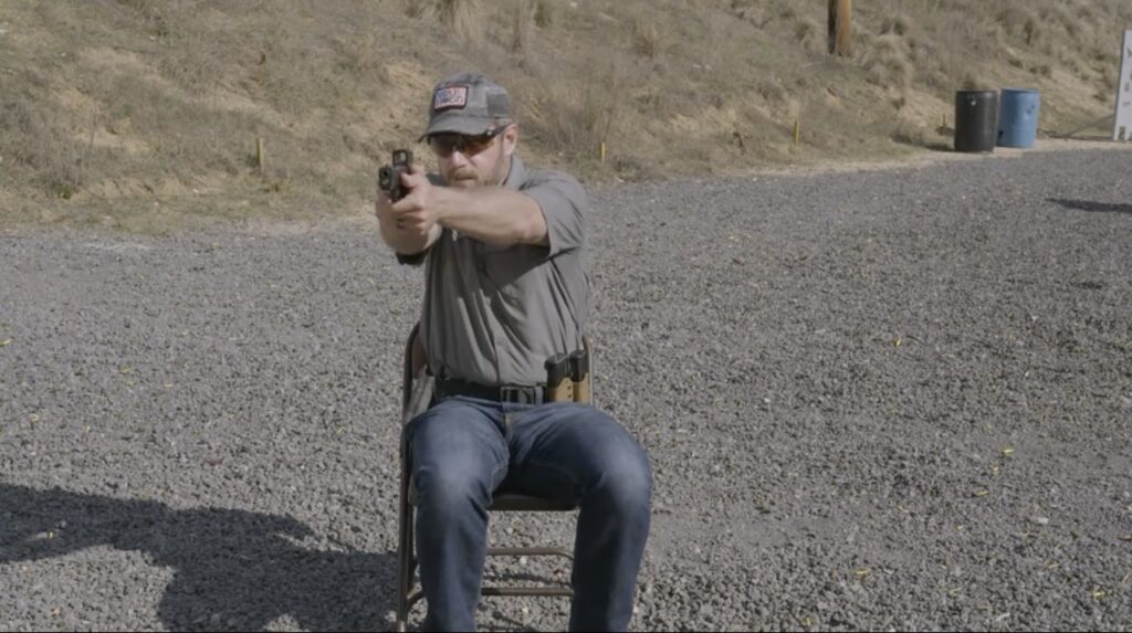 in the photo is Rick Hogg from War HOGG Tactical practicing shooting from a seated position on the range using a folding chair