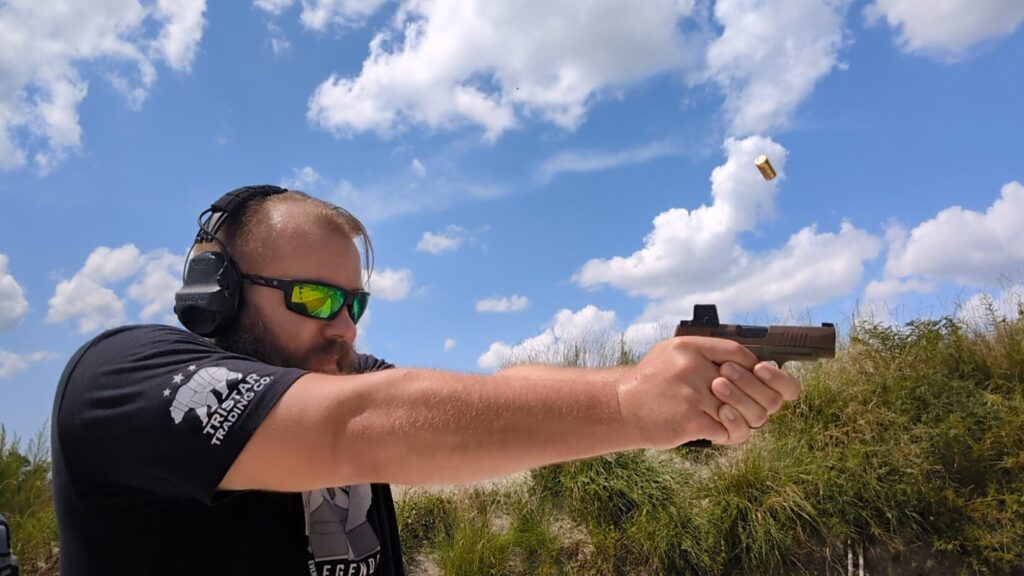 Man shooting Sig Sauer P365 pistol, spent casing visible in the air after coming out of ejection port.