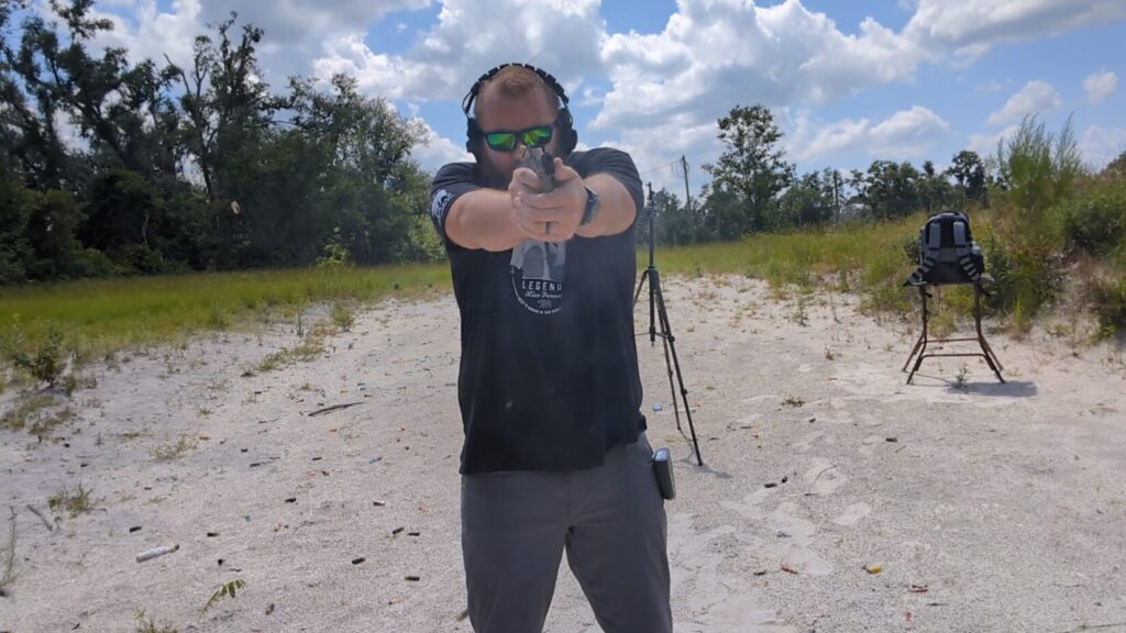 Man firing Sig Sauer P365 pistol, spent casing in air.